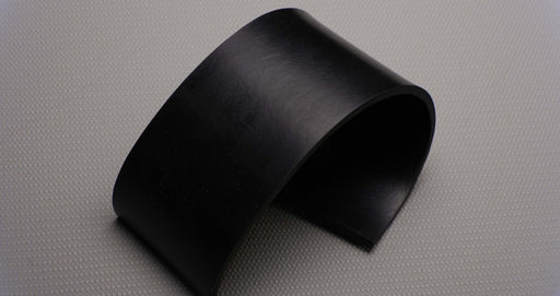 Photo showing the top and bottom sides of a MOR rubber conveyor belt. The belt is black with a thickness of 3/16". It features a durometer of 50, a tensile strength of 1000 psi, and an elongation of 400% with temperature resistance from -20F to +170F.