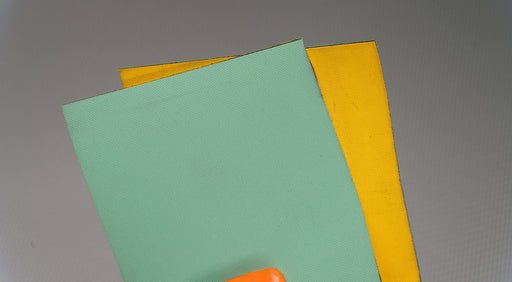 Front and back view of nylon conveyor belt showing yellow diamond surfacing on top and green diamond surfacing on bottom, 2mm thickness.