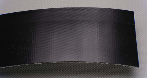 Front view of a PVC conveyor belt with a smooth top and brush bottom. The belt is 9/64" thick, with a black top and bottom, and a strength of 1% elongation at 0.073 lbs/in.