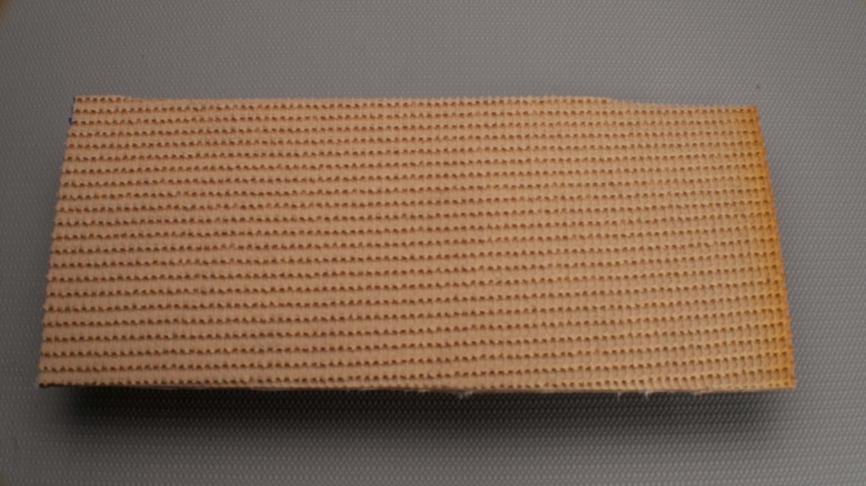 Photo showing the top side of a rubber conveyor belt with a Pure Gum rough top. The belt is brown on the bottom and has a thickness of 7.24 mm. The top features Pure Gum, while the bottom has a bare RLF fabric. The belt has a strength of 150 lbs/in.