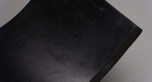 Close-up view of skirtboard rubber conveyor belt material, 1" thickness, black color, smooth surfaces, durometer 55-75, tensile 1650 psi.