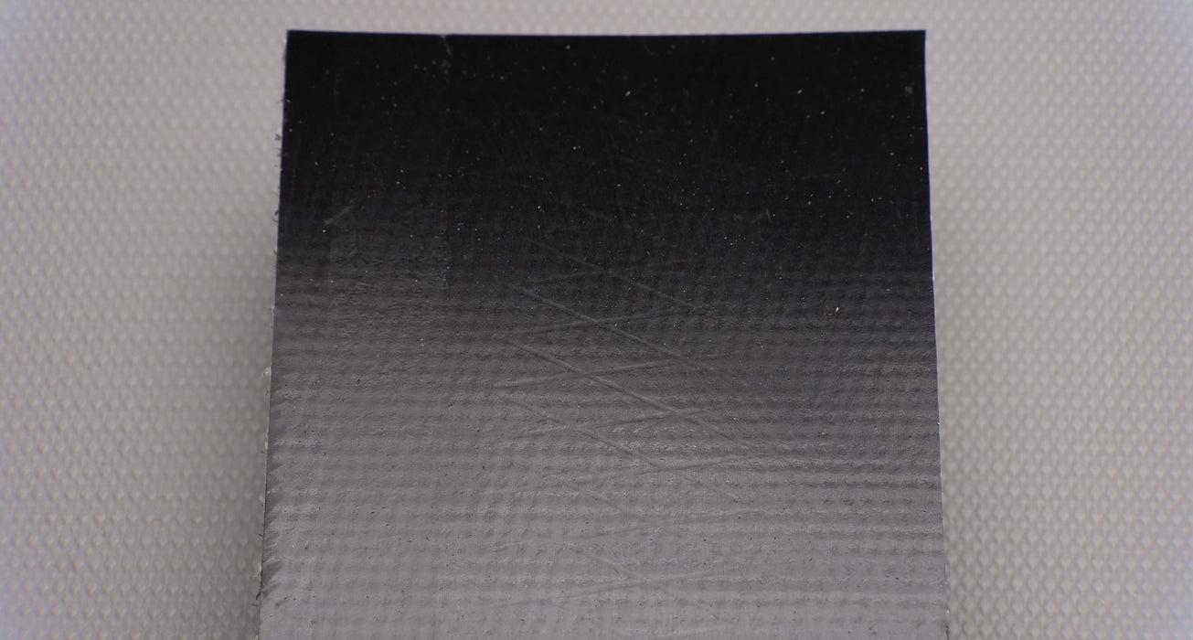 Front view of PVC conveyor belt with smooth black top, 9/64 inch thickness, made from interwoven fabric with 0.073 lbs/in strength.