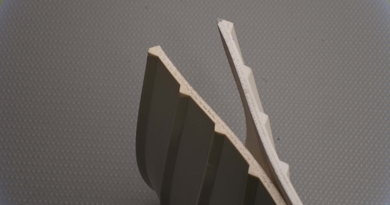 Back view of RMV conveyor belt showing thickness of 0.25 inch, white meat-cleat top, and fabric bottom.