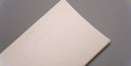 Front view of rubber conveyor belt with smooth white surface, 3/16 inch thickness, durometer 60, tensile strength of 700 psi, and elongation of 300%.