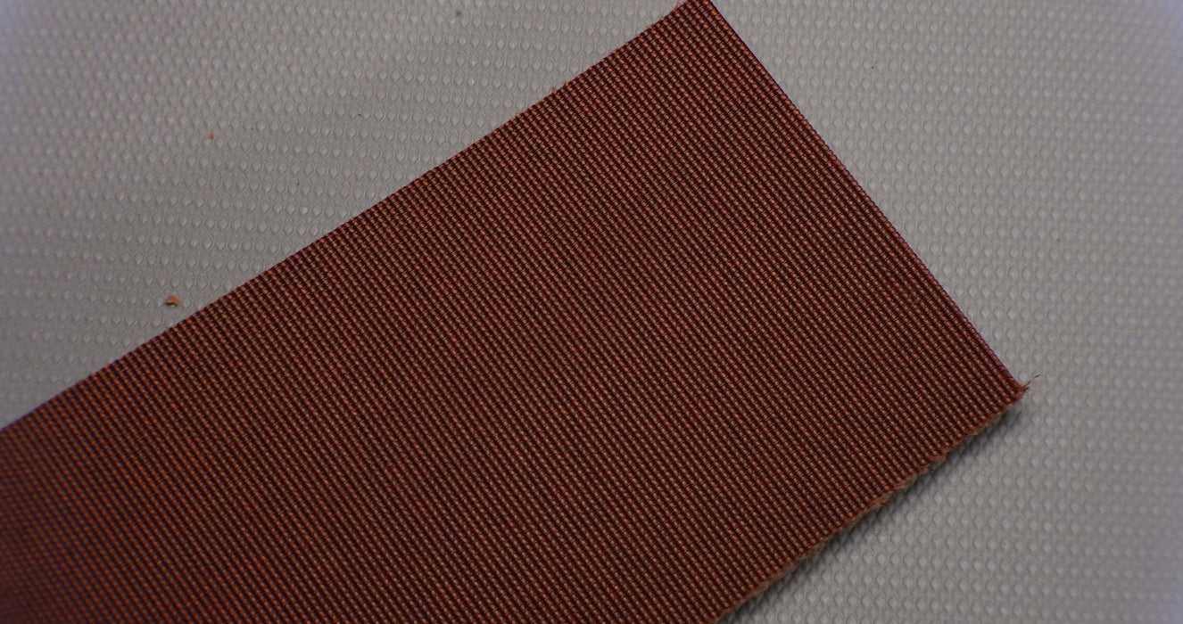 Polyester layering on rubber conveyor belt with black top and brown bottom