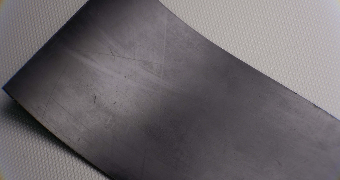 Thin profile of black rubber conveyor belt.