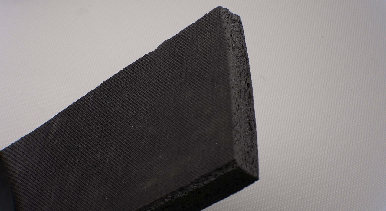 Photo displaying the thickness of an EPDM rubber conveyor belt with 1/4 inch thickness, black open cell structure on both the top and bottom sides.