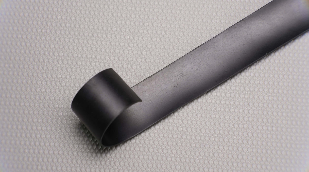 Photo showing the back side of a MOR rubber conveyor belt, featuring black rubber on both sides with a thickness of 1/32".





