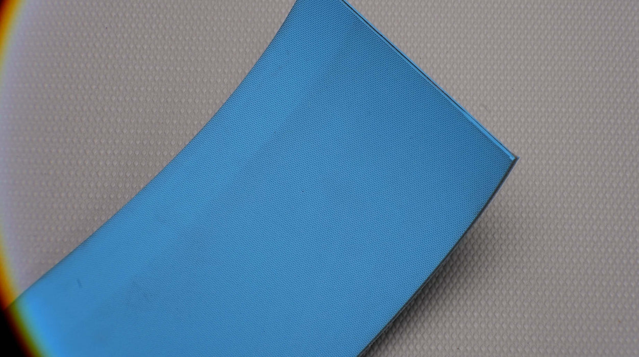 Close-up of the front side of a nylon conveyor belt with a diamond surfacing pattern. The belt is blue, 5mm thick, and features a single layer with a strength of 1% elongation at 3.8 nm.







