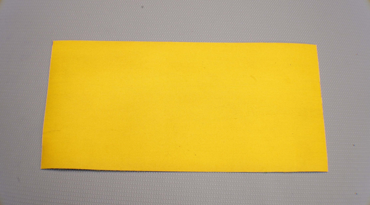 Back and bottom view of NC nylon conveyor belt, 0.8 nm thickness, yellow top and green bottom, fabric material, 1 layer, 1% elongation at 1.8 N/mm.
