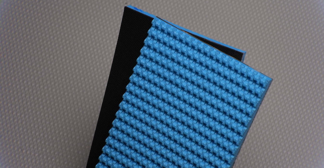 Front and back side of an NRT-500 conveyor belt with 5 layers and 6.0 mm thickness. The top features a rough texture and is blue, while the bottom is fabric with a black color. Made from NBR with 1% elongation strength of 20%.