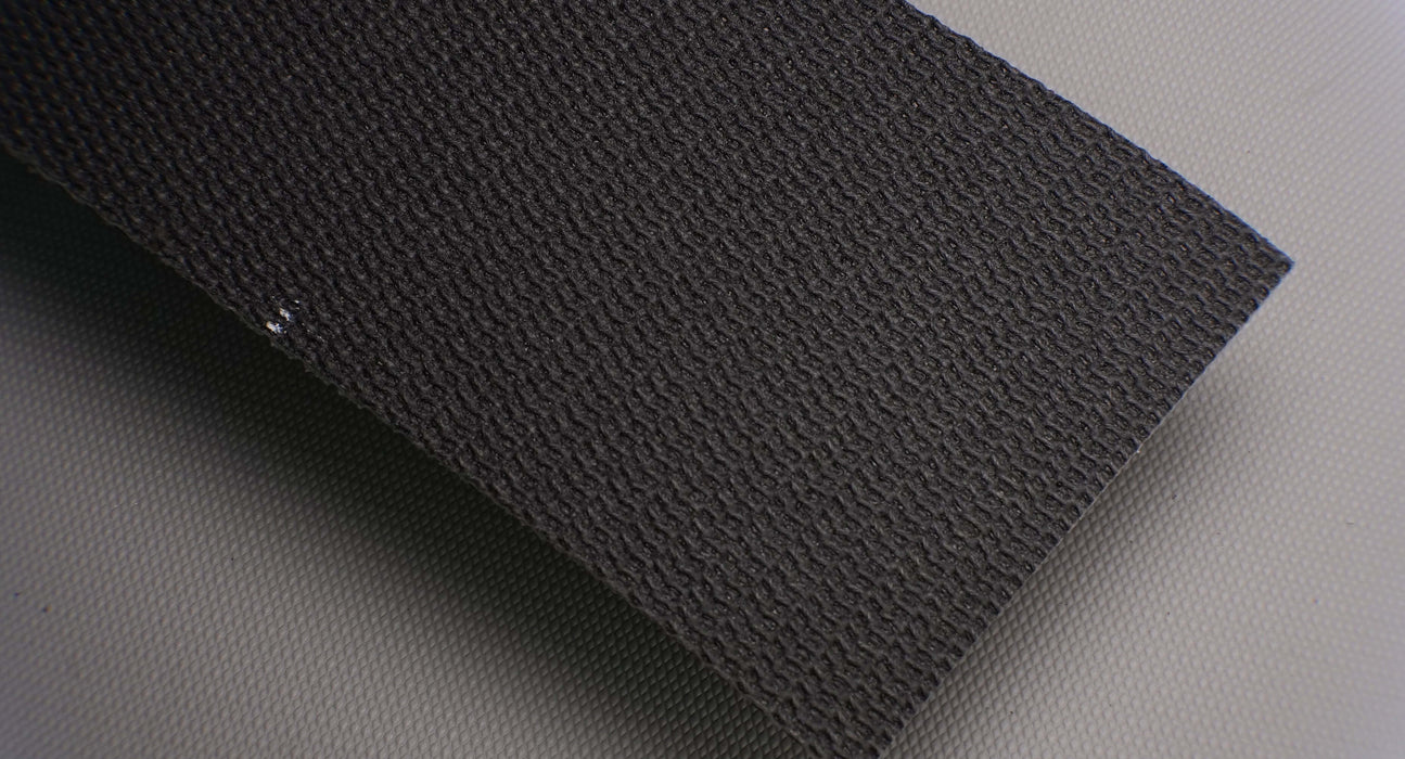 Photo showing the front side of a PVC conveyor belt with 3.5mm thickness, black fabric on both the top and bottom sides, with interwoven layers and a strength of 1% elongation at 28nm.







