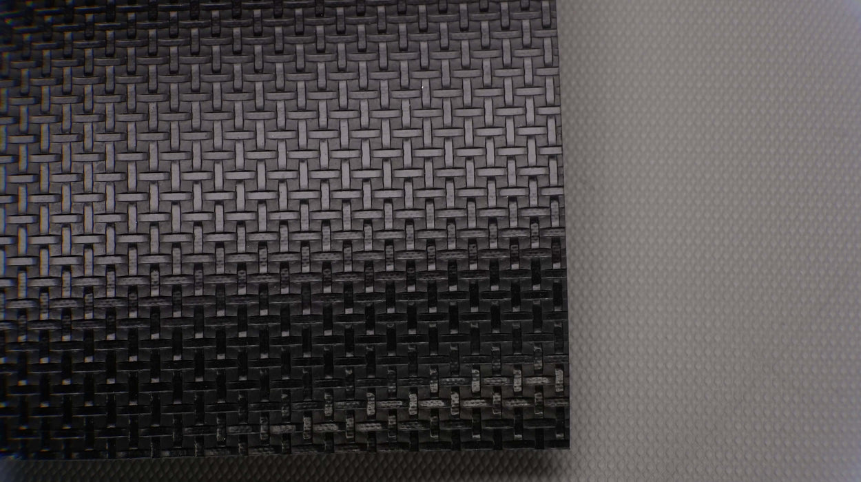 Photo showing the front side of a PVC conveyor belt with a black basket weave top and white fabric bottom. The belt features a thickness of 2mm and a monofilament fabric.






